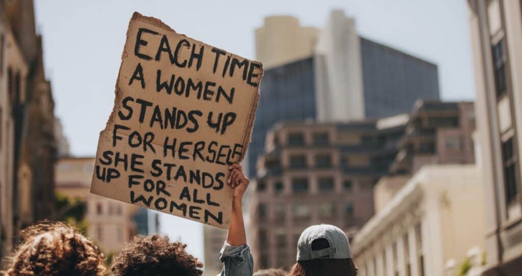 A handmade cardboard sign held aloft at a women’s rights march